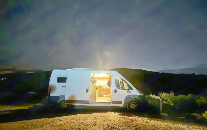 Stargazing night! An RV rental camper van with a lit interior and a person inside, under a dark sky with stars and a comet.. RAM Promaster 2500 159wb 2018
