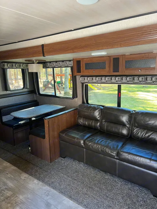 Comfortable RV rental interior: dinette, sofa, and inviting living space ready for travel.. Heartland RVs Pioneer 2018