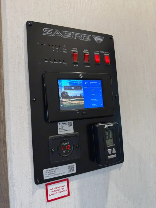 RV rental control panel: Lippert OneControl touchscreen for slides, lights, water. Shows 11.2V, Airxcel thermostat.. Forest River Sabre 2022