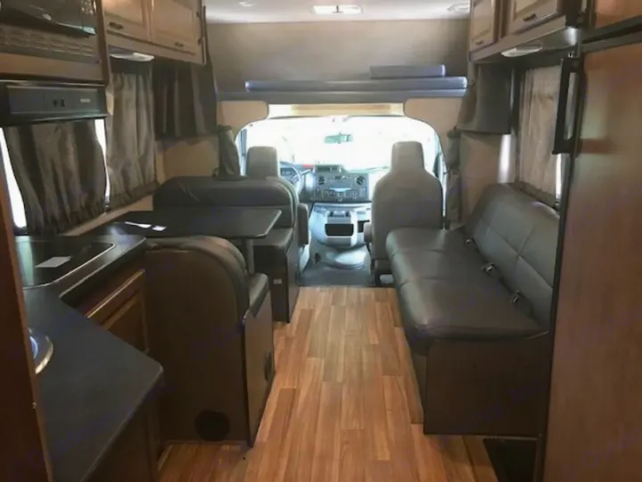 Spacious rv rental interior featuring a kitchen with microwave, comfortable dinette, and a living area with sofa seating.. Thor Majestic 2019
