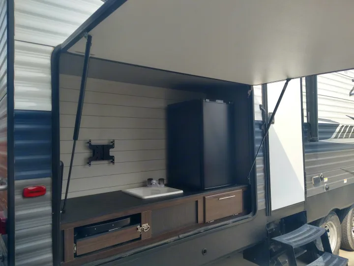 RV rental travel trailer with an outdoor kitchen: sink, mini-fridge, and TV mount, expanding your living space.. Crossroads RV Zinger 2020