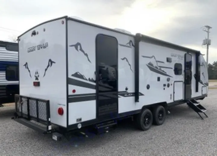 White travel trailer with black mountain & wolf graphics. This modern toy hauler is ideal for your RV rental camping adventure.. Forest River Cherokee Grey Wolf 2022