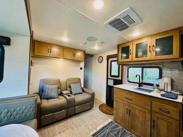 Spacious RV rental interior featuring a living area with recliners, overhead storage, and a well-equipped kitchen.. Forest River Coachmen Freedom Express 2025