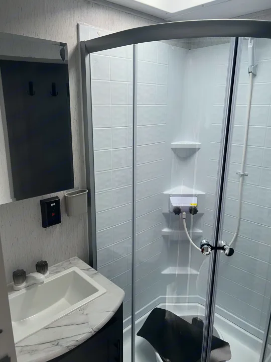 Compact RV rental bathroom with a sink, mirror, and modern shower, perfect for travel.. Aspen Trail Aspen Trail Trailer 2021
