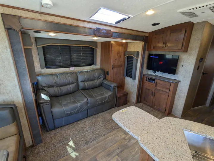 Spacious rv rental interior with comfortable sofa, TV, and kitchen area, perfect for your next travel adventure.. Outdoors RV Timber Ridge 2022