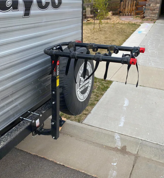 Rear of an RV rental, featuring an Allen bike rack mounted on the Jayco spare tire. Parked on a sidewalk.. Jayco Jay Flight SLX Baja Edition 2020