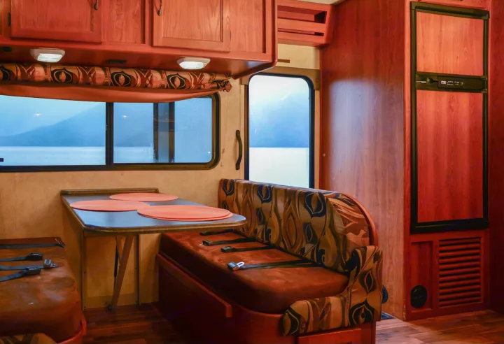 RV rental: Dinette with table, bench seating & overhead cabinets, plus a refrigerator and a scenic water view.. Forest River Coachmen Freelander 2014