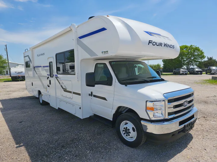 Discover this white Thor Four Winds Class C RV rental, parked on a gravel lot and ready for your next adventure.. Thor Motor Coach Four Winds 2026