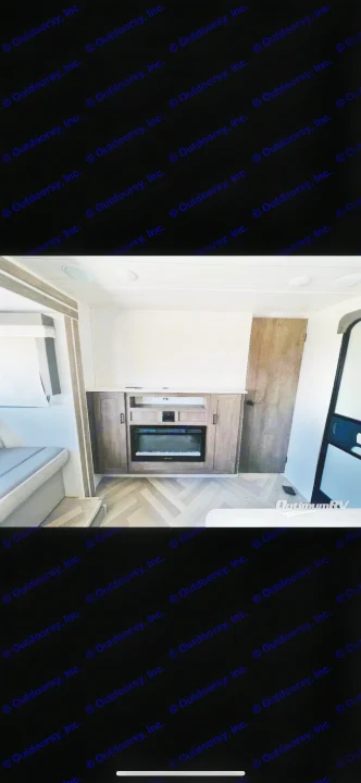 RV rental interior features a stylish entertainment center with an electric fireplace, herringbone floors, and cozy seating.. Forest River Wildwood X-Lite 2022