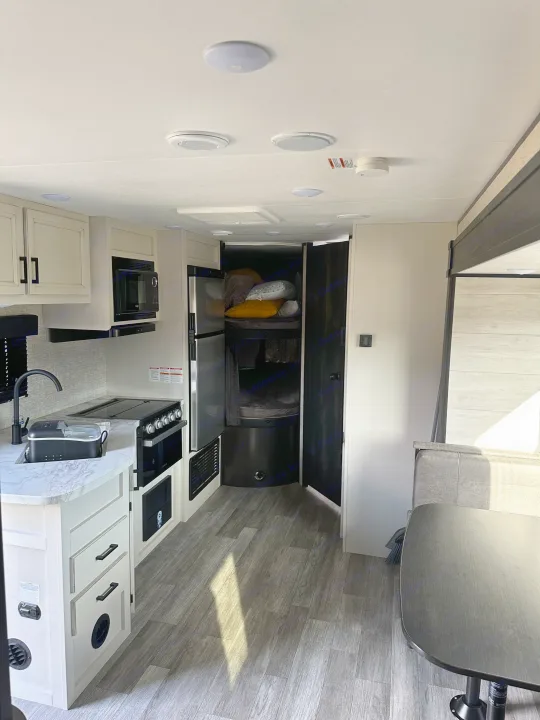 Spacious RV rental interior featuring a modern kitchen, dining area, and cozy bunk beds. Ideal for your next trip.. Jayco Jay Flight SLX 2022