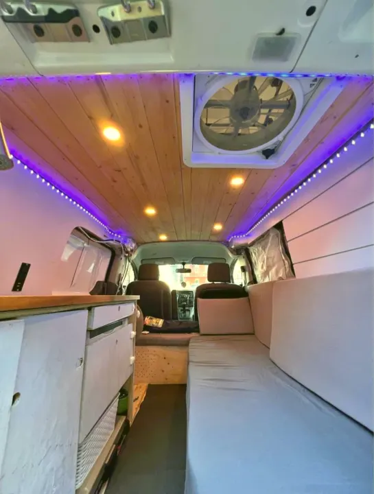 Step inside this cozy RV rental! Features include a wooden ceiling, purple LED lights, compact kitchen, and comfortable bed.. Nissan NV200 2015