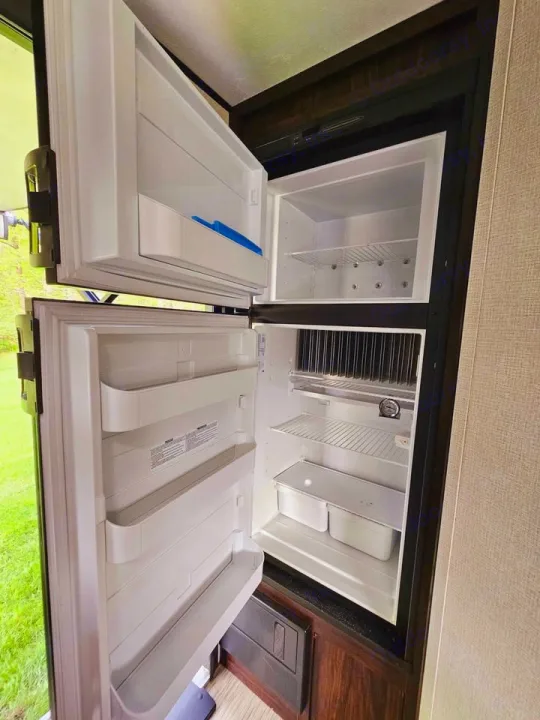 Spacious, clean open RV rental refrigerator with separate freezer and fridge compartments, ready for your trip's groceries.. Forest River Tracer Breeze 2020
