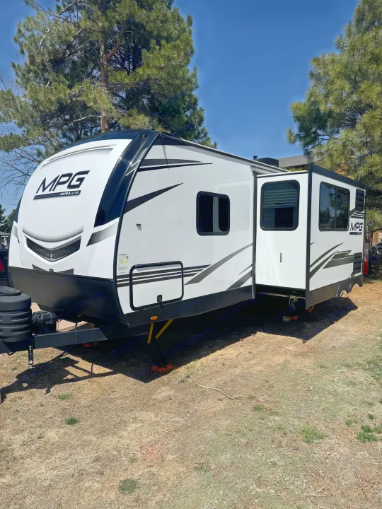 White MPG Ultra-Lite travel trailer RV rental, slide-out extended, parked on dry ground, ready for adventure.. Cruiser RV MPG 2500BH 2024