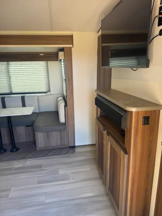 Explore this cozy rv rental dinette with modern finishes, wall-mounted TV, and ample storage.. Cruiser RV MPG 2500BH 2024