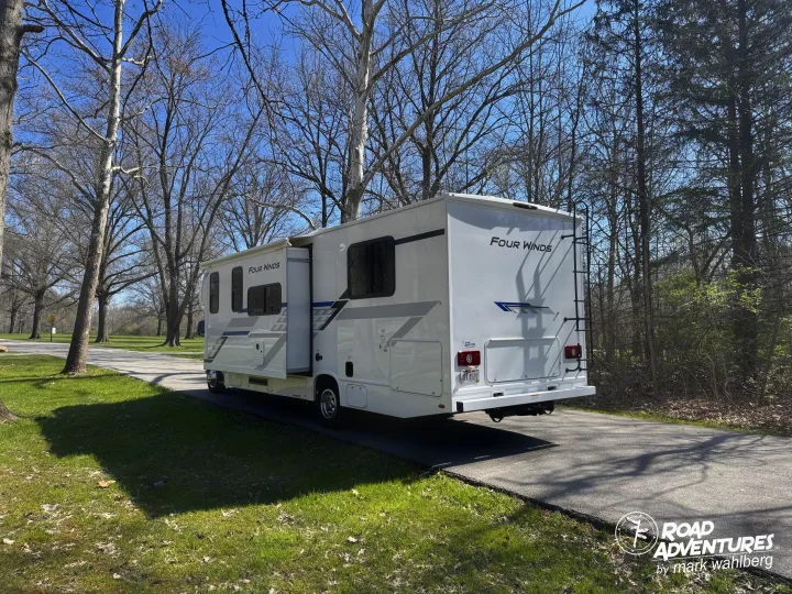 Four Winds rv rental parked on a sunny path, surrounded by bare trees, ready for road adventures.. Thor Motor Coach Four Winds 28Z 2026