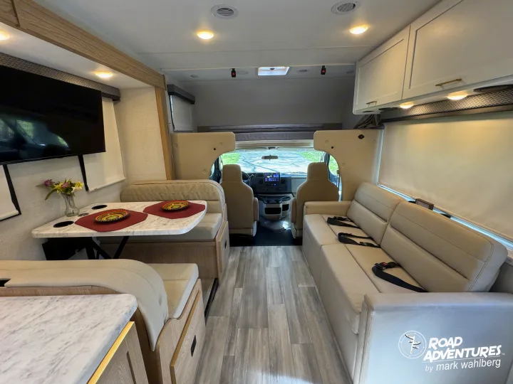 Explore this modern & spacious rv rental interior, featuring a cozy dinette, sofa, and cockpit, perfect for road adventures.. Thor Motor Coach Four Winds 28Z 2026