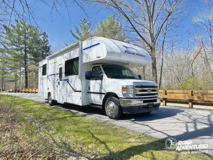 This Thor Four Winds Class C rv rental is parked on a sunny road among trees, ready for a memorable adventure.. Thor Motor Coach Four Winds 28Z 2026