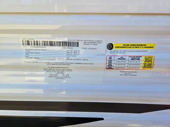 RV rental compliance sticker for a Keystone trailer, detailing vital weight, tire, and capacity information.. Keystone RV Springdale 2023