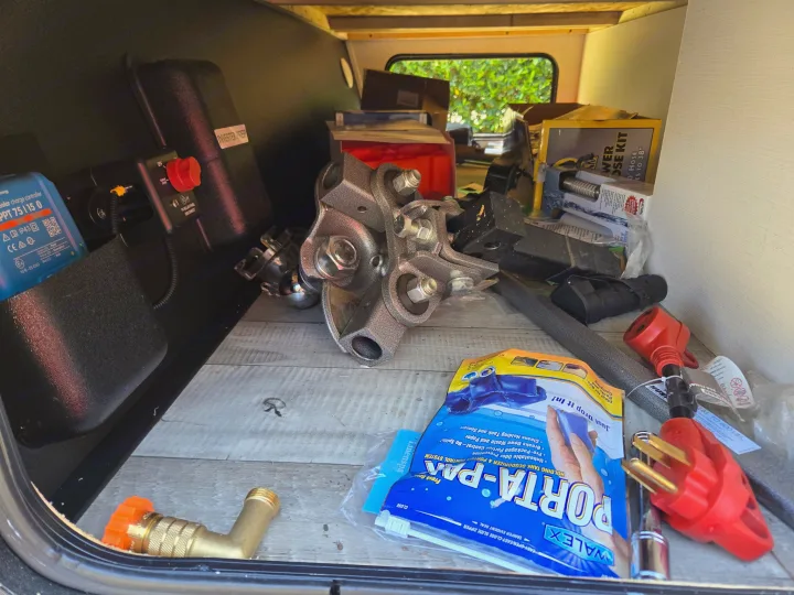RV rental utility storage: solar charge controller, essential electrical adapters, and holding tank treatment. All for the road.. Keystone RV Springdale 2023