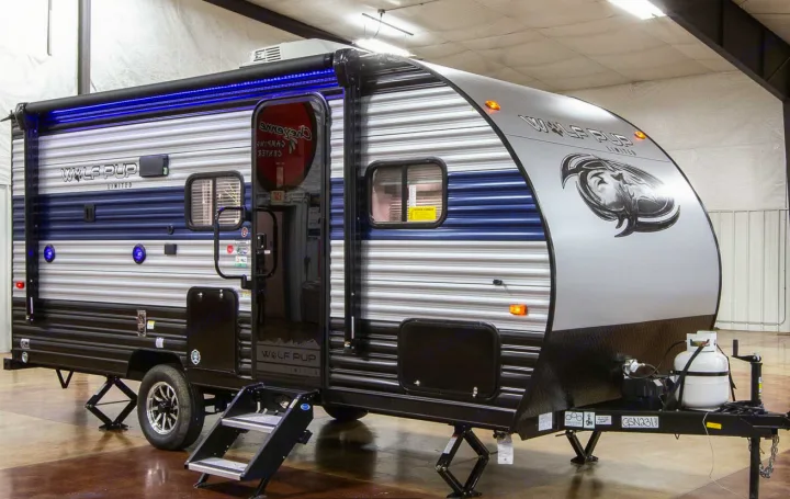 This Wolf Pup Limited travel trailer, an excellent rv rental choice, features blue accent lights and a front propane tank setup.. Forest River 17' Bunkhouse 2025