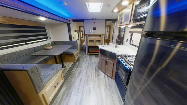 Spacious RV rental interior with modern kitchen, comfortable dinette, and cozy fireplace for your next adventure.. Forest River 26' Bunkhouse with Slide 2025