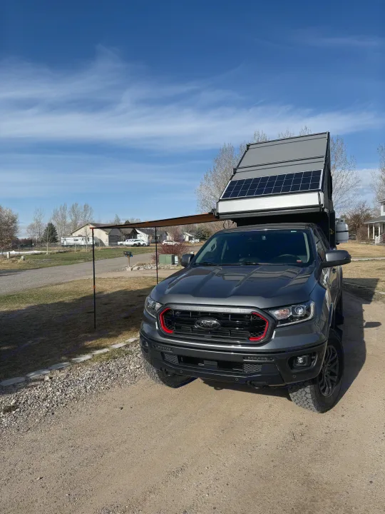This grey Ford truck features an RV rental-style pop-up camper with solar panels and an awning, ready for overlanding.. Ford Ranger 2300 Cc 2022
