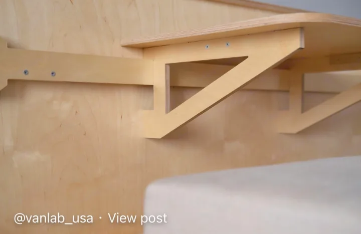 Clean plywood shelving and bed setup in an RV rental interior, ideal for van life storage.. Ram Promaster City 2018