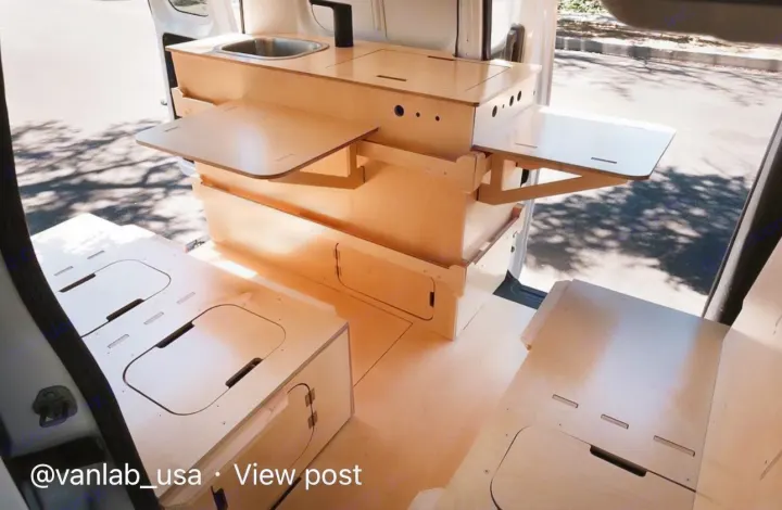 Inside a modern van conversion: modular plywood setup with sink, pull-out tables, and floor storage. Ideal for rv rental.. Ram Promaster City 2018