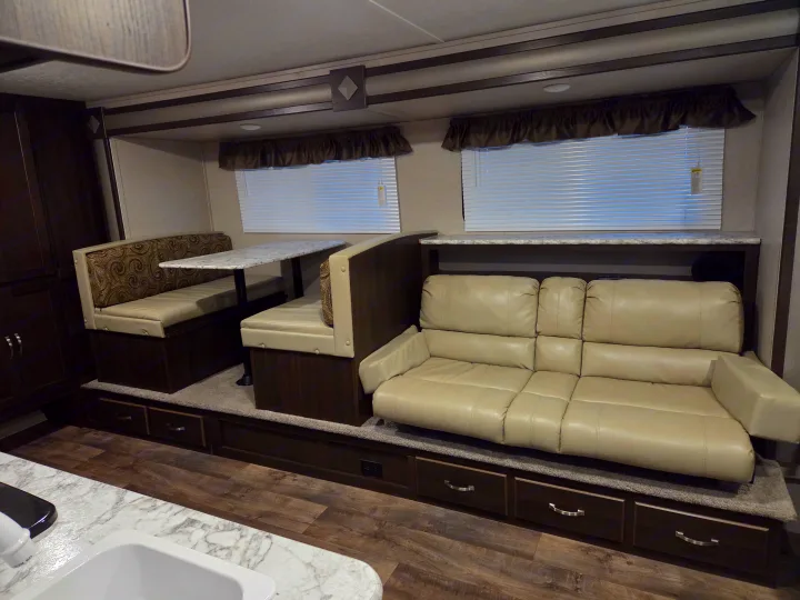 Spacious RV rental interior featuring a comfy dinette, sofa, and practical storage. Perfect for road trips!. Keystone RV Springdale 2019