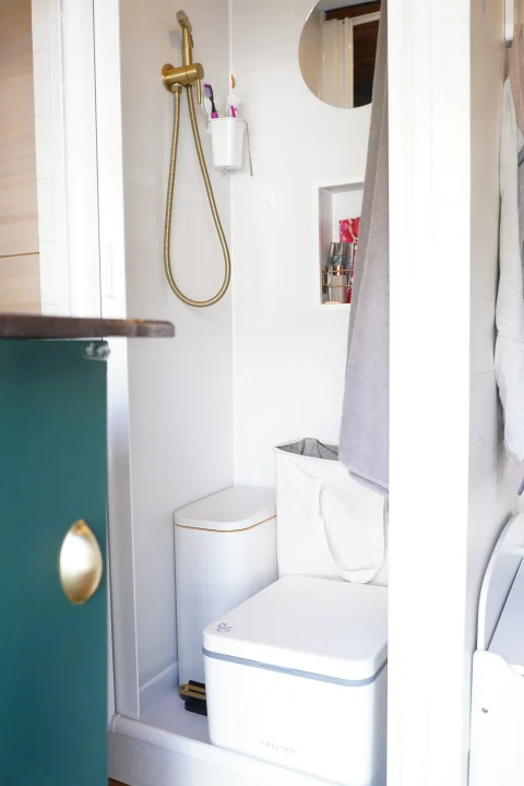 Inside an RV rental: a modern bathroom with gold fixtures, toothbrush holder, mirror, and a space-saving Trelino composting toilet.. Ford Transit Custom 2022