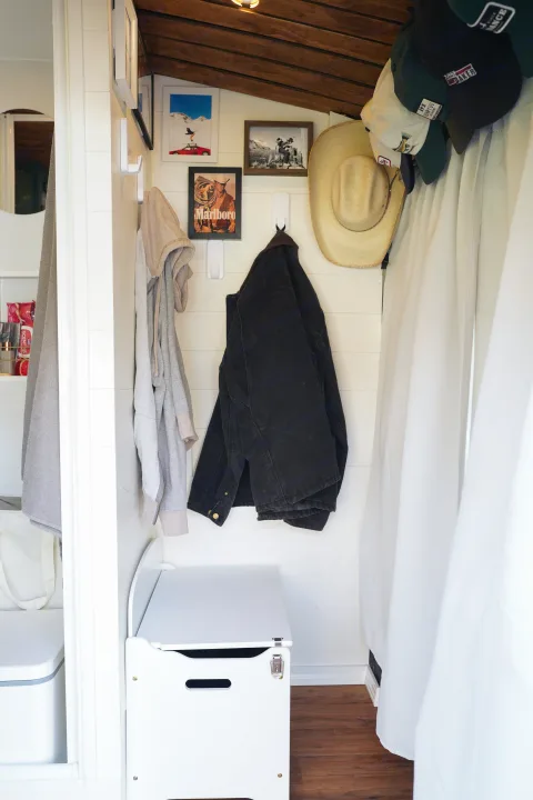 Cozy RV rental entryway with practical coat hooks, personal decor, and smart storage bench for compact living.. Ford Transit Custom 2022