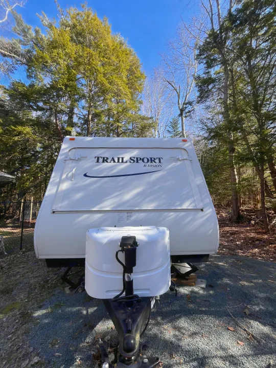 White Trail Sport RV rental parked for outdoor adventures in a sunny, tree-filled setting.. R-Vision Trail Sport 2014