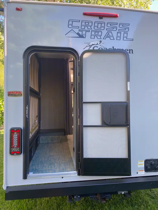 An RV rental's rear entry, with open main and screen doors, offers a glimpse into its modern interior.. Ford Transit 2023