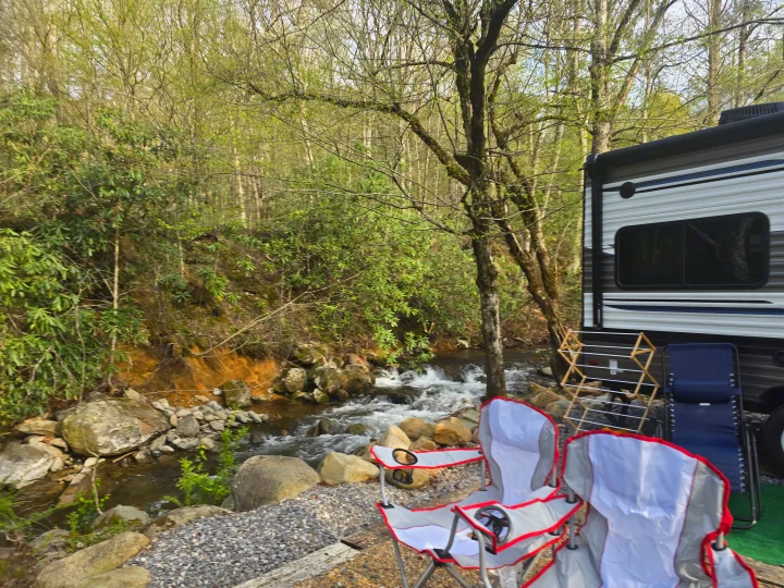 RV rental campsite by a scenic river with lush trees and comfortable chairs. Enjoy nature's peaceful flow.. Palomino Puma 2022