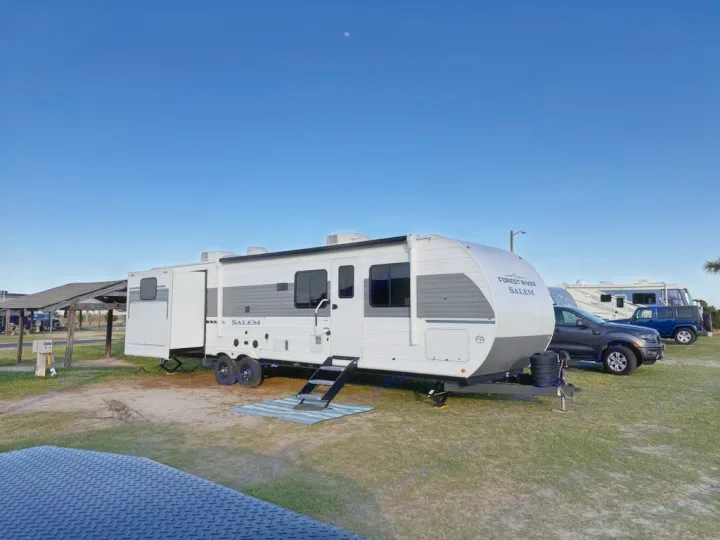 This Forest River Salem RV rental is parked and set up at a sunny campground under a clear blue sky with a moon.. Forest River Salem 31kqbts 2025