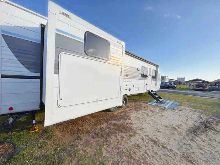 This spacious RV rental, a travel trailer with a slide-out, is ready at a sunny campground for outdoor adventure.. Forest River Salem 31kqbts 2025