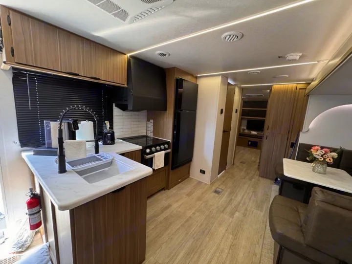 Explore this bright RV rental's modern interior, featuring a full kitchen with light cabinets and a cozy dining area.. Forest River Salem 31kqbts 2025