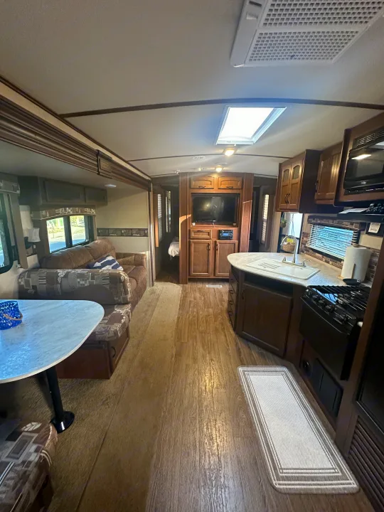 RV rental interior: full view of living, kitchen, and bedroom spaces, with wood-look flooring and a skylight.. Jayco White Hawk Ultra Lite 2015