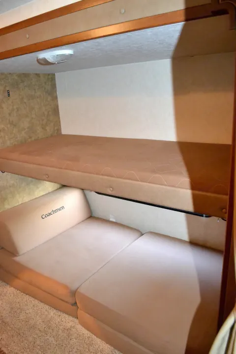 RV rental bunk beds: comfortable sleeping area with Coachmen cushions in a travel trailer.. Coachmen Freedom Express 2013