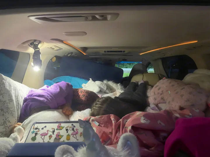 Two children sound asleep in a cozy vehicle, transformed for comfortable vehicle camping, similar to an RV rental.. Toyota Dreamseeker Voyager 2008