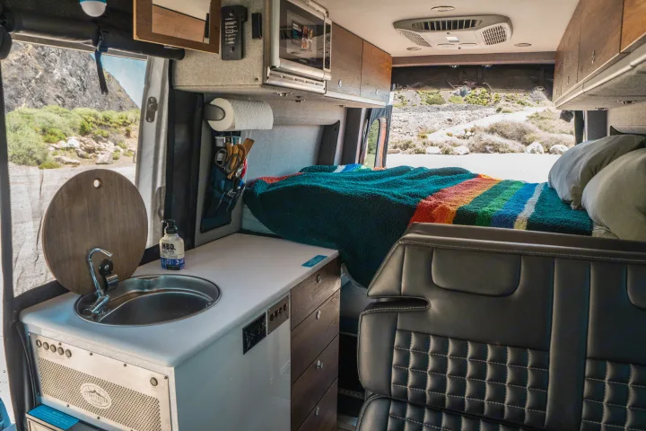 Explore this Storyteller Overland RV rental's well-appointed interior with a kitchen, comfy bed, and mountain views.. Storyteller Overland Storyteller Overland Class B 2022