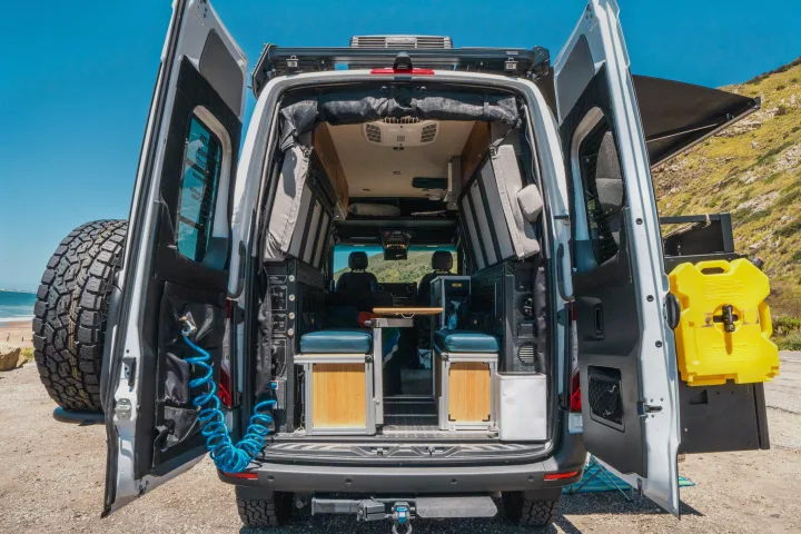 Explore with this RV rental camper van! Rear doors open, revealing custom interior, outdoor shower, spare tire, and fuel can.. Storyteller Overland Storyteller Overland Class B 2022