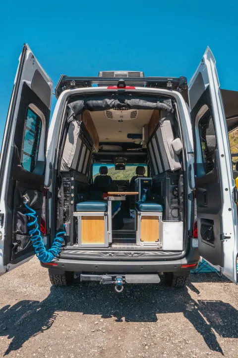 Customized RV rental camper van with open rear doors showing its well-equipped interior for road trips.. Storyteller Overland Storyteller Overland Class B 2022