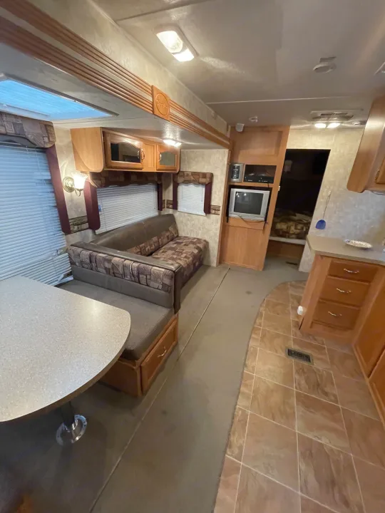 Inside this rv rental, a comfortable living space with a dinette, sofa, kitchen area, and mixed flooring.. Forest River Cherokee 2008