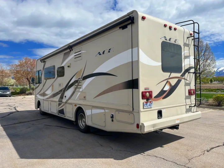 Spacious beige ACE RV, a perfect rv rental, parked outdoors under clouds, ready for your next adventure or road trip.. Thor A.C.E. 2016