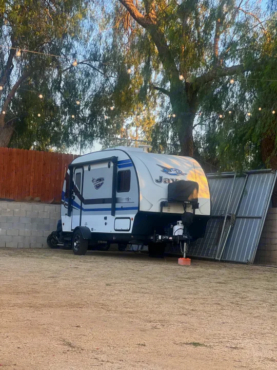 Experience comfort in this Jayco Hummingbird RV rental, parked on gravel under string lights and trees.. Jayco Hummingbird 2019