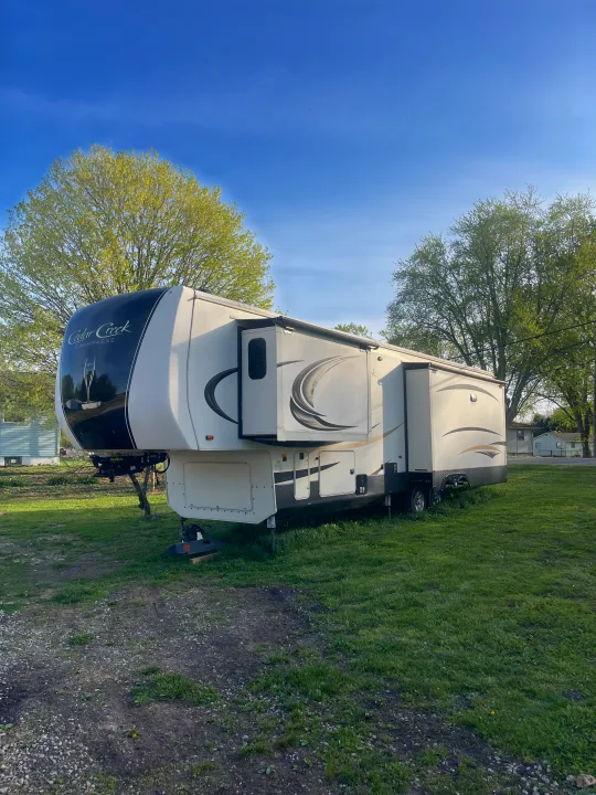 Cedar Creek Champagne fifth wheel RV rental, parked with slide-outs open. Ideal for your next adventure!. Cedar Creek Champagne 2019