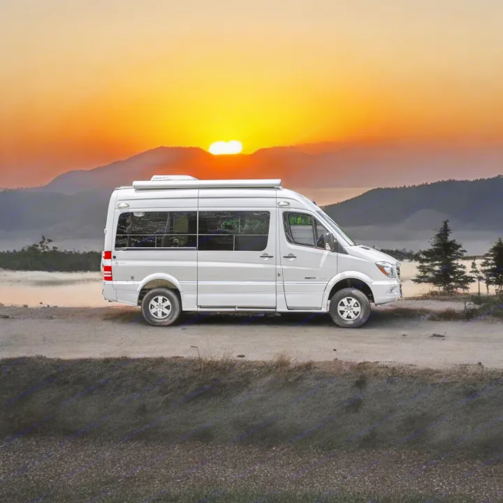 White camper van RV rental on a dirt road, glowing sunset over mountains and water. Your next adventure awaits!. Roadtrek Roadtrek Class B 2017