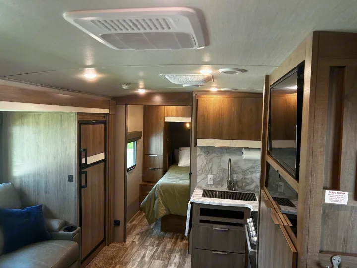 Step inside this RV rental's modern interior, showcasing a compact kitchen, comfortable living area, and inviting bedroom.. Grand Design Imagine 2022
