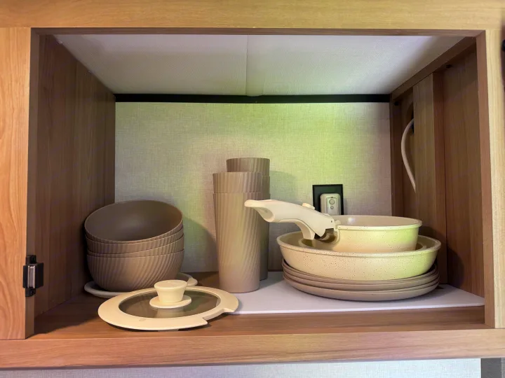 RV rental: Compact cabinet neatly storing stackable bowls, cups, pots, pans, and plates for your adventures.. Keystone RV Coleman 13B 2025